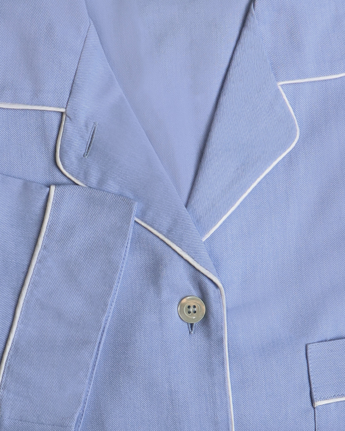 Close-up of a light blue pajama set with white piping