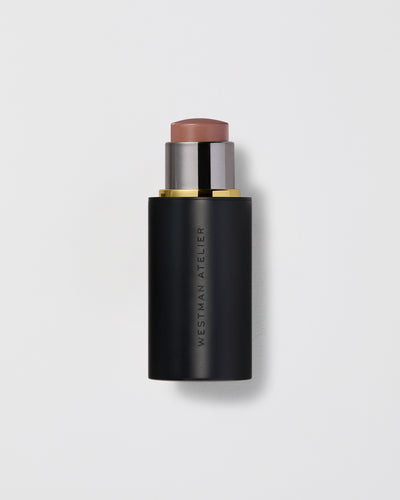 Black cosmetic stick with a brown top on a light gray background