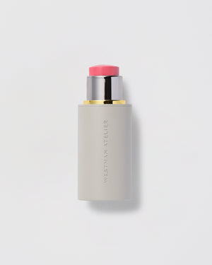 Cosmetic stick with pink cap on a light gray background.