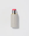 Cosmetic stick with pink cap on a light gray background.