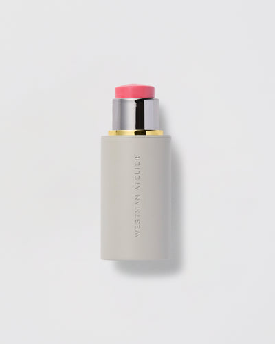Cosmetic stick with pink cap on a light gray background.