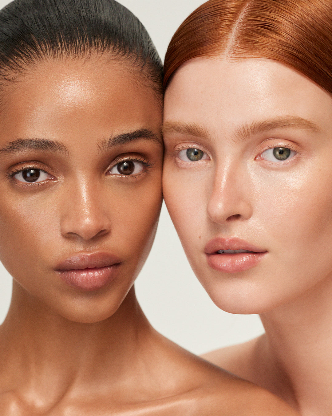 Two women with close-up faces on a neutral background