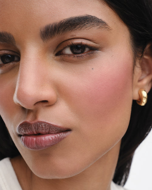 Model wears the Baby Cheeks Powder Blush Duo in Fizz/Jam. 