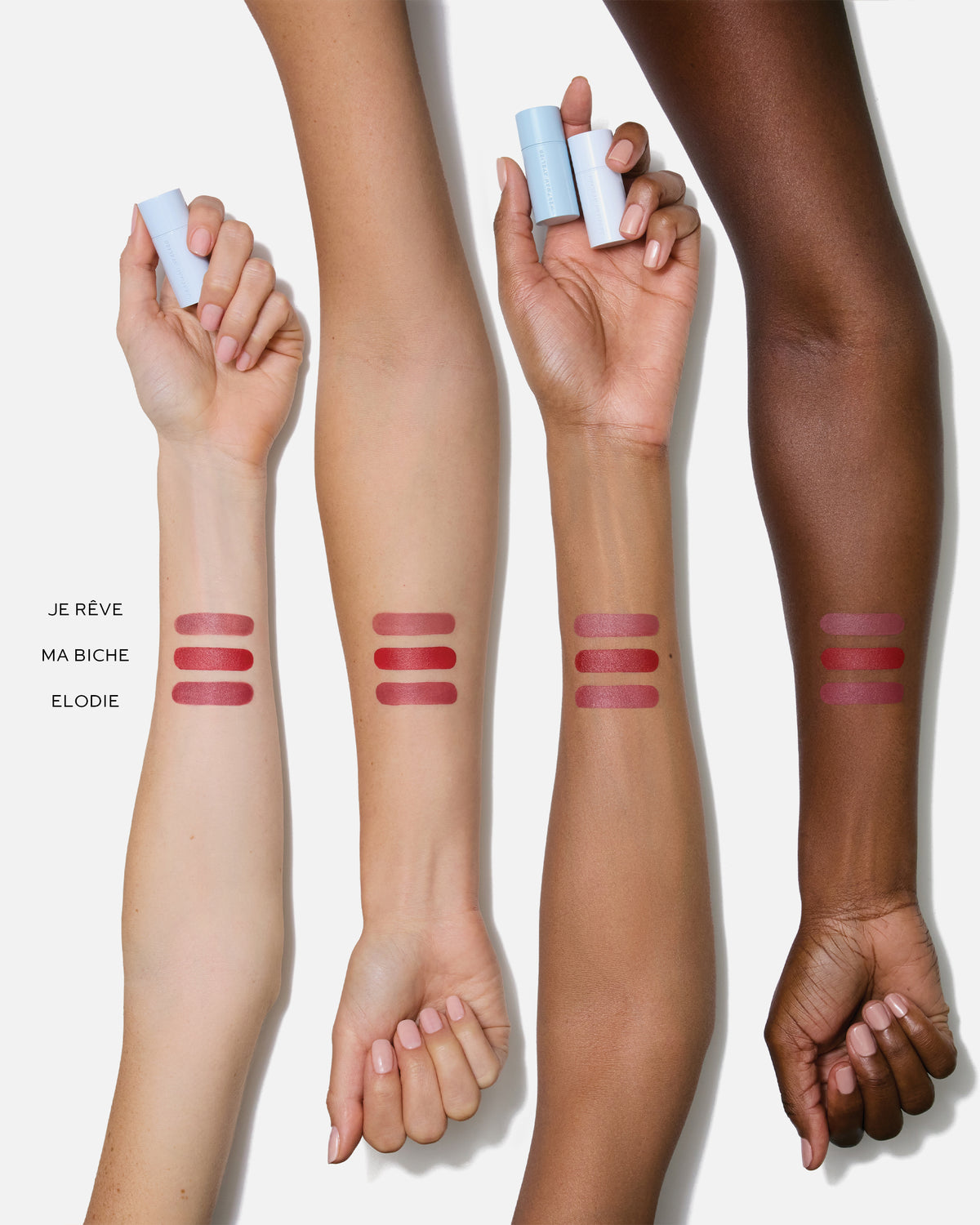 Three arms with different skin tones displaying lipstick swatches on a white background.
