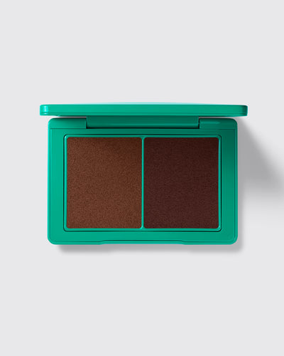 Green makeup compact with two brown shades on a light gray background