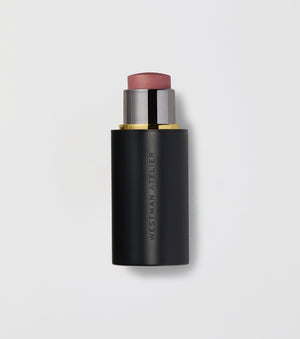 Black makeup stick with pink top on a light gray background.